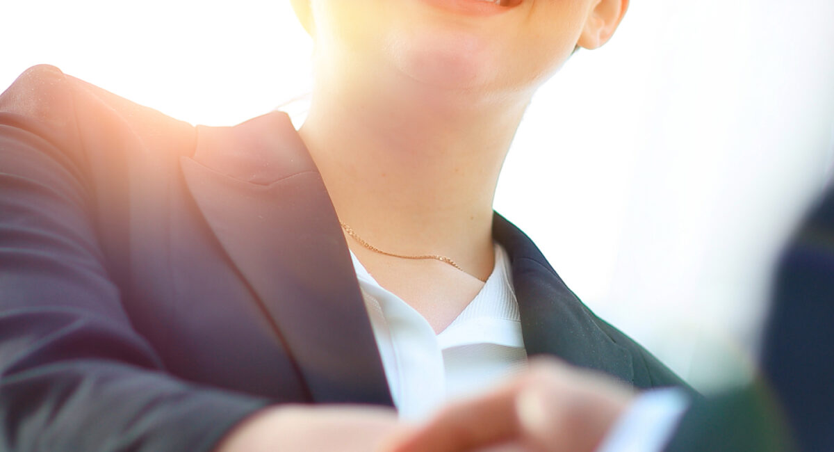 Business Law Facts - closeup of business woman shaking hands with her business partner.